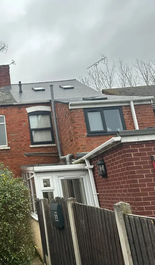 The rear of a red brick terraced house on The Willows, with a conservatory and a slate roof.