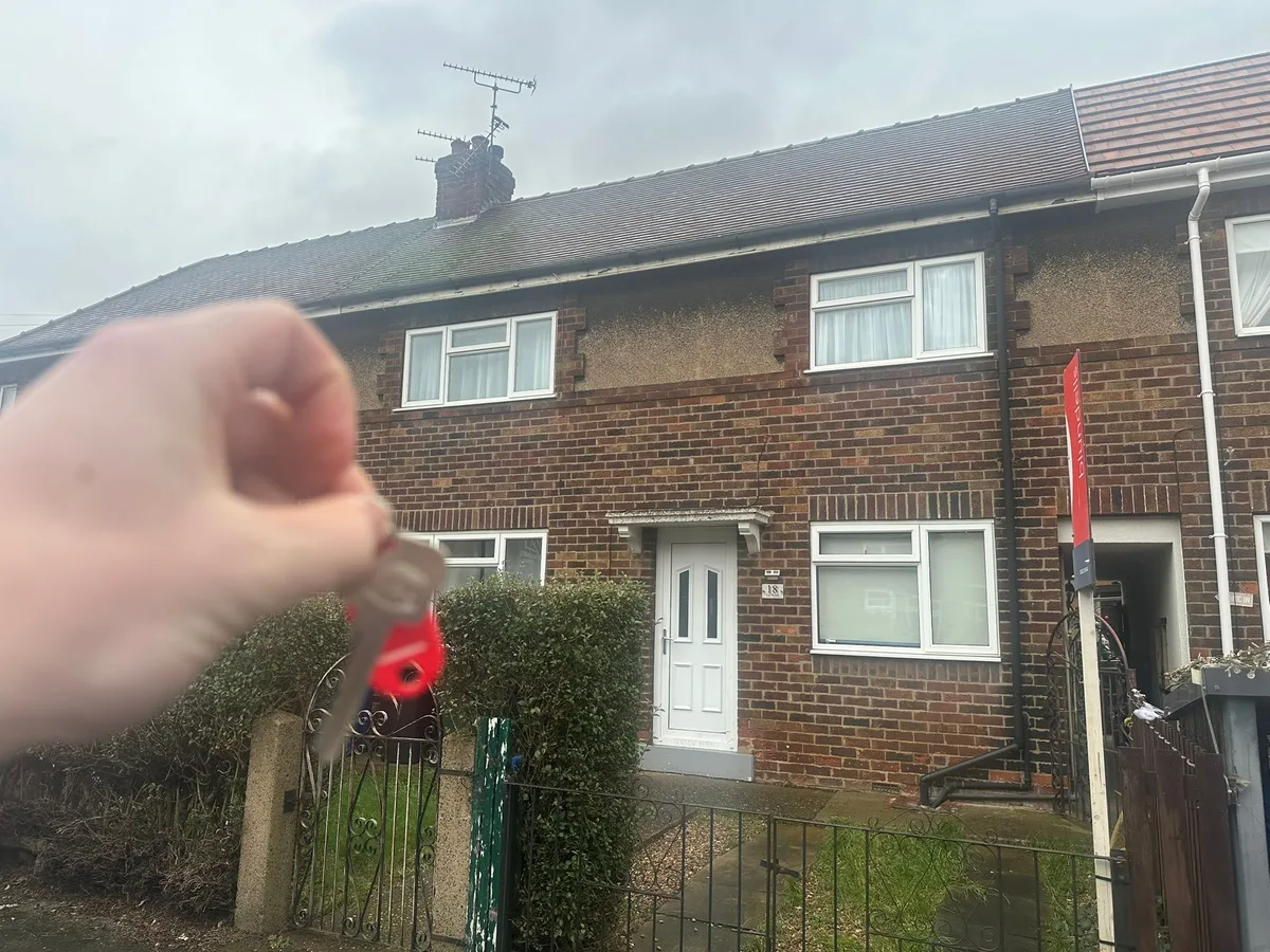 Keys held up in front of a house on Ely Road.