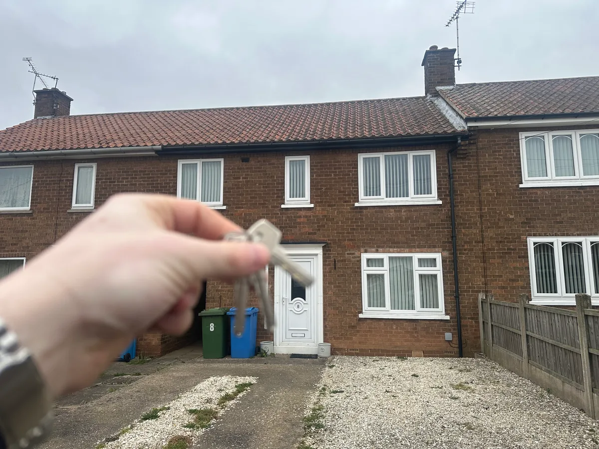 Keys held up in front of a house on Hawthorne Way.
